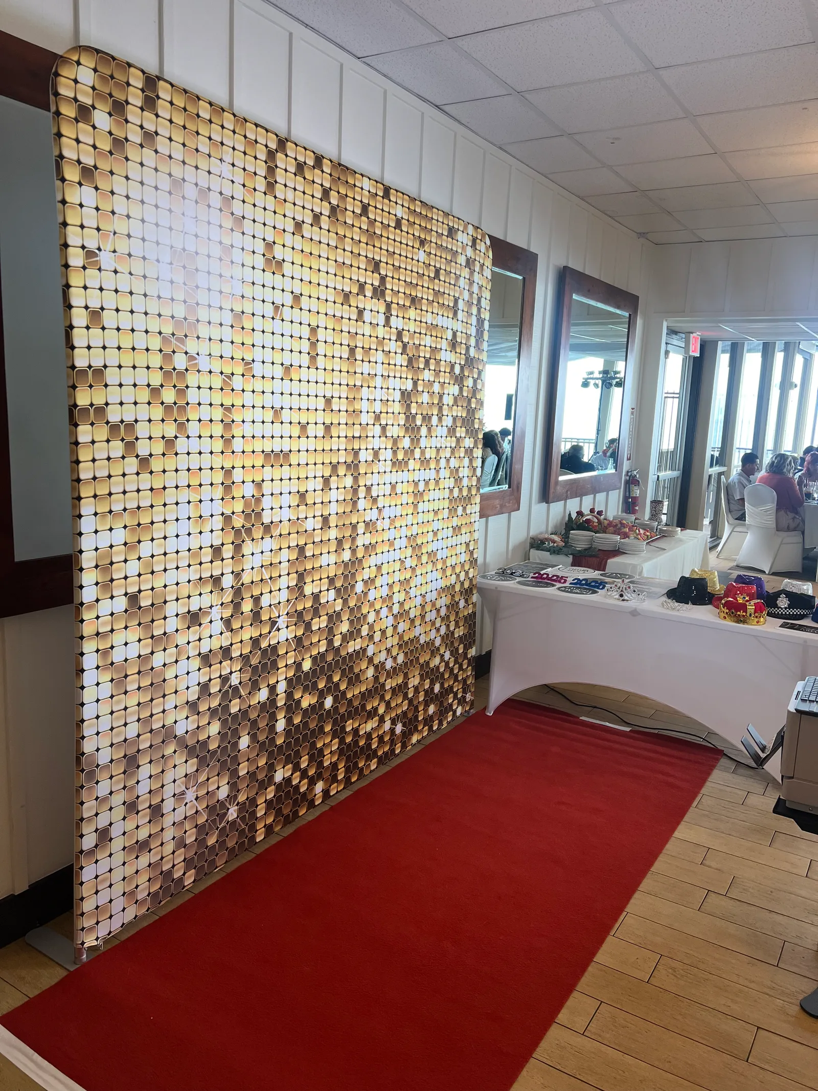 Gold shimmer wall backdrop with red carpet and stanchions