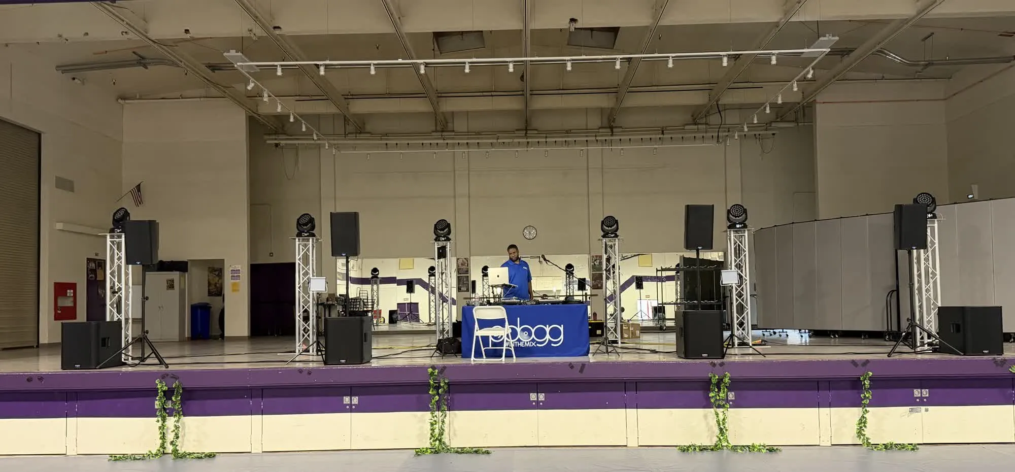 Lighting truss totems with moving-head lights and speakers across a stage