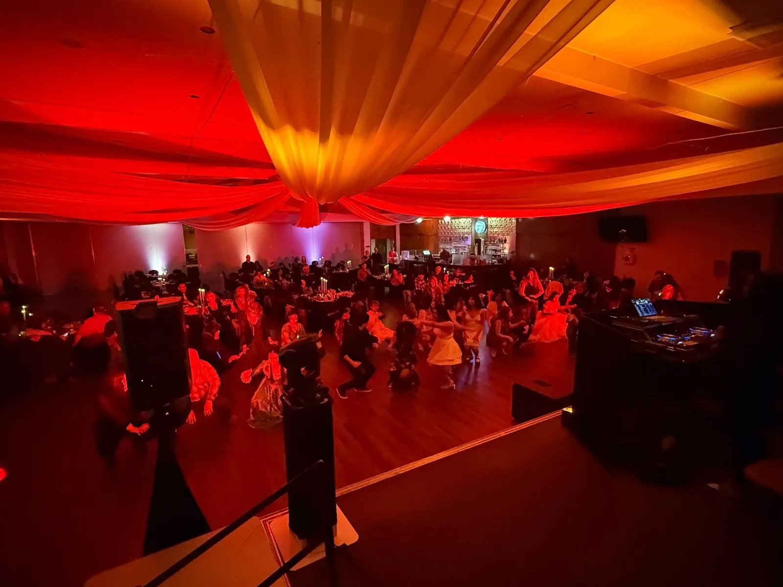 Quinceañera reception with red uplighting, draped ceiling, and EPiK Productions sound system